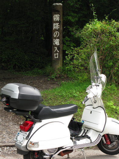 🛵「霧降の滝入口」の看板前に停車する白いベスパ