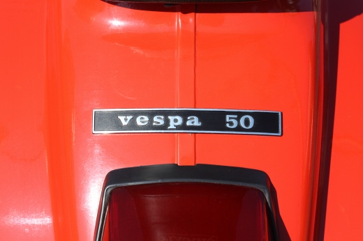路上に停車中の赤いvespa50Rのフロントビュー全体