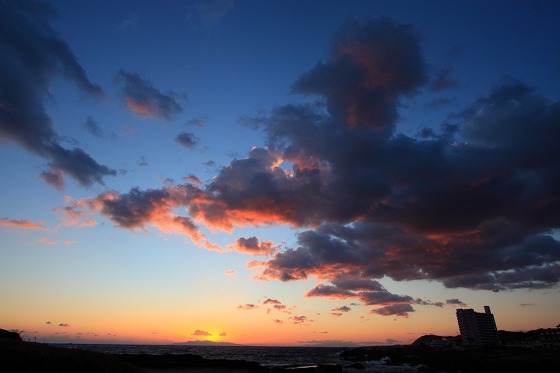 水平線に沈む夕日と野島埼灯台。空のグラデーションが幻想的。
