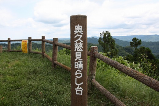 奥久慈見晴らし台の木柱と柵、背景には広がる山々と空