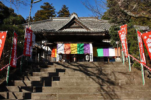 石段の上に建つカラフルな幕をかけたお寺の本堂
