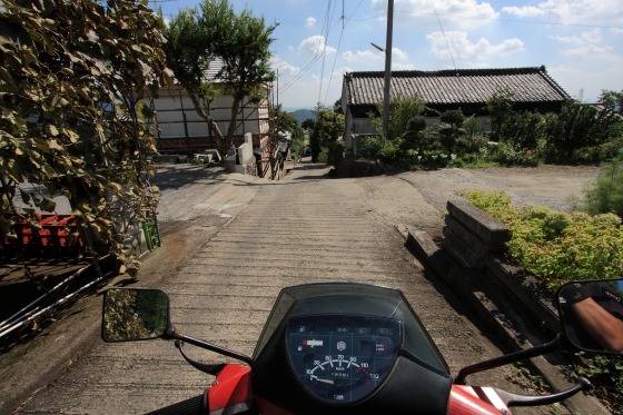 地震で通行止めになったつくば道、Vespaのメーター越しに坂を望む