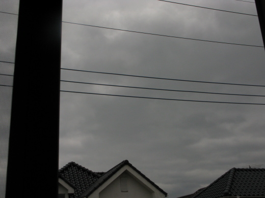 雨雲に覆われた空を室内から眺めた景色