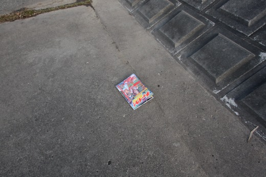 アスファルトの上に落ちているカラフルなエロ本