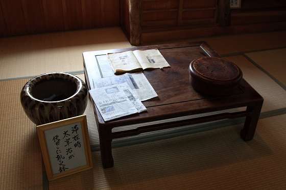 太宰治が実際に使用していた机と火鉢が展示された室内。