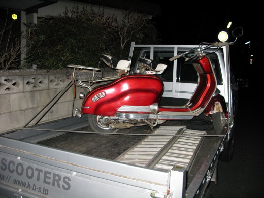 トラック荷台に積まれた赤いランブレッタの納車準備中