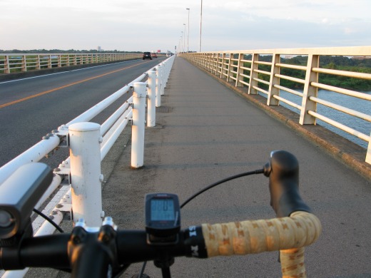 利根川にかかる長い橋を自転車ハンドル越しに見た風景