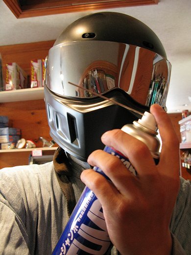 フルフェイスヘルメットを装着しスプレーを手に構える姿