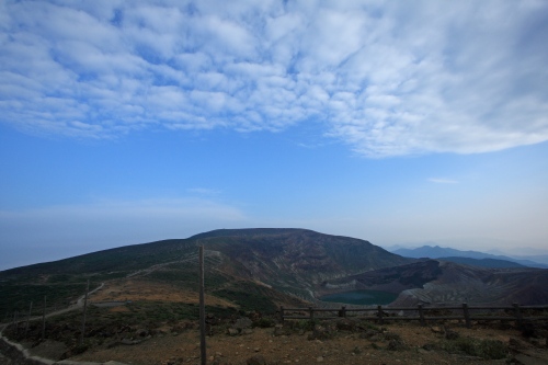 お釜と蔵王の山並みを遠望する広がりのある風景