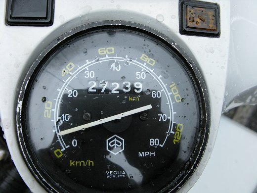雨粒がついたベスパのスピードメーター。走行距離は27,239kmを示す。