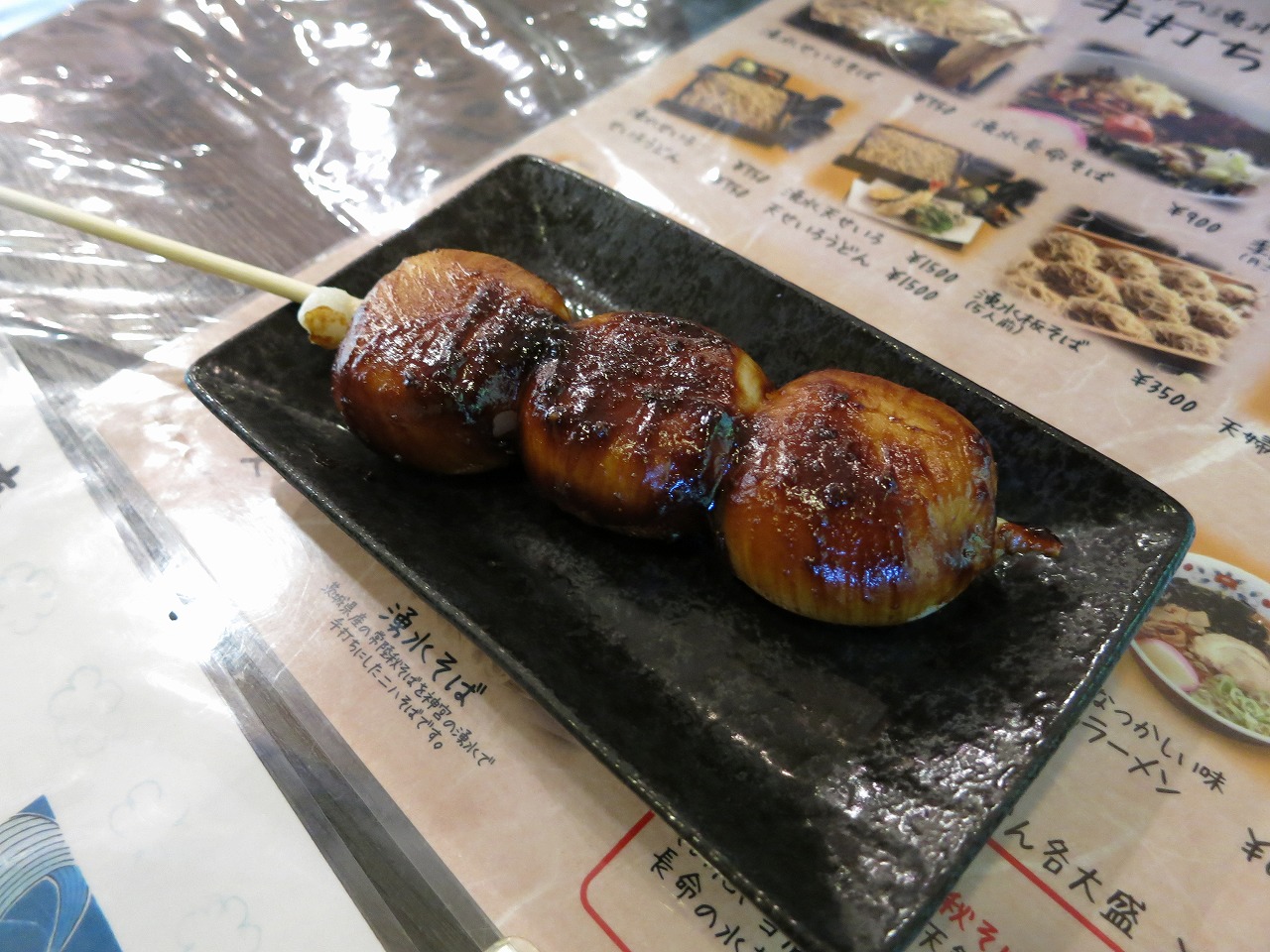メニュー表の上に置かれた香ばしい焼きみたらし団子