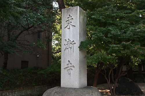 「東漸寺」と刻まれた石柱と周囲の木々