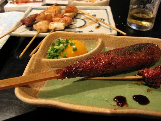比内地鶏の串焼きとつくねが並ぶご当地居酒屋の一皿