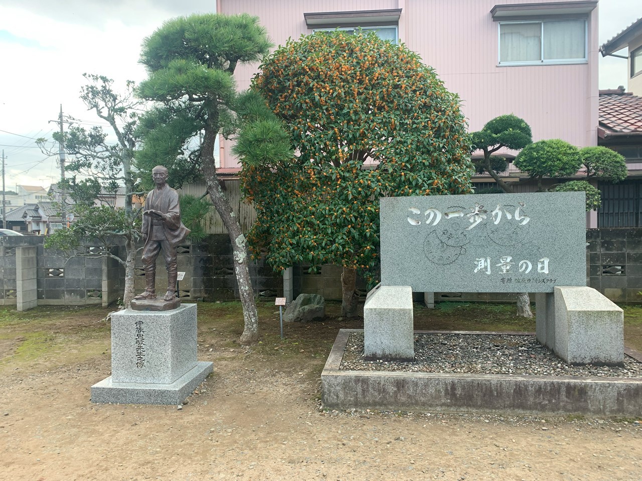 「この一歩から測量の日」と刻まれた石碑と伊能忠敬の銅像。