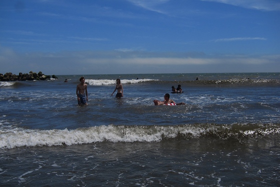 海水浴を楽しむ人々、穏やかな波と青空