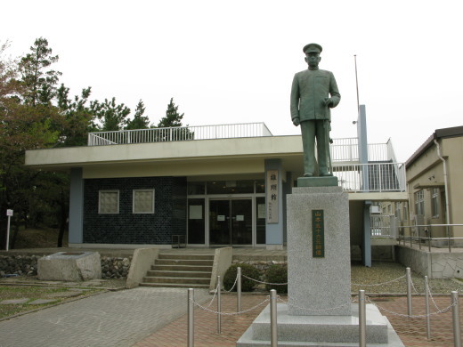 霞ヶ浦予科練記念館「雄翔館」とその前に立つ軍服姿の銅像