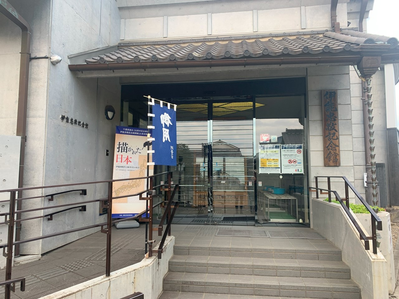 伊能忠敬記念館の正面入口。展示の案内ポスターが掲げられている。