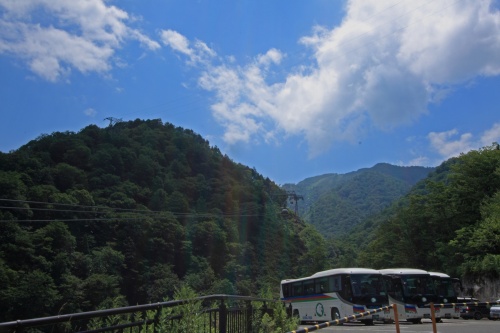 ロープウェイ乗り場と観光バス、山に囲まれた風景