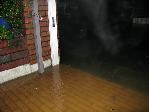 玄関前まで冠水した道路と建物
