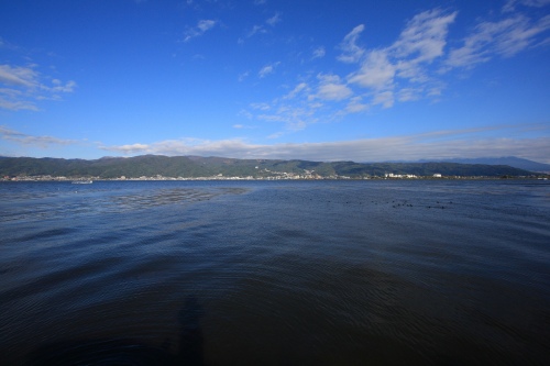 諏訪湖の湖面越しに望む山と青空