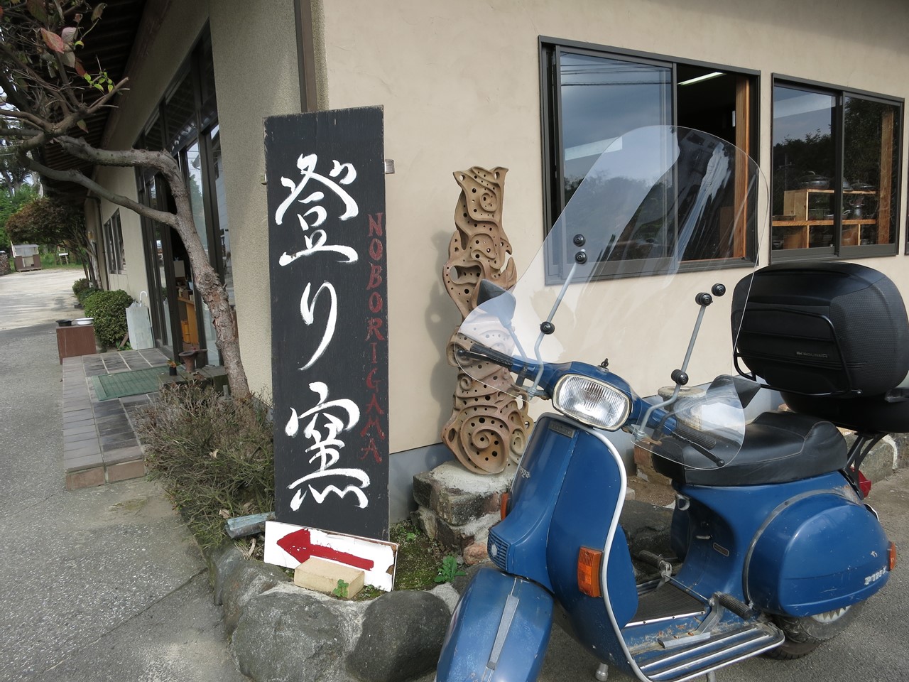 登り窯の看板とその前に停めた青いベスパ