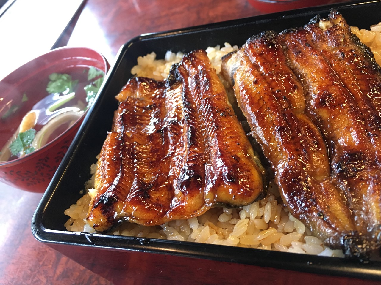 ご飯と吸い物が並ぶ豪華なうな重のアップ