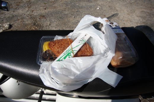 ベスパのシートの上に置かれた焼きおにぎりと麦茶。小休憩のひととき。