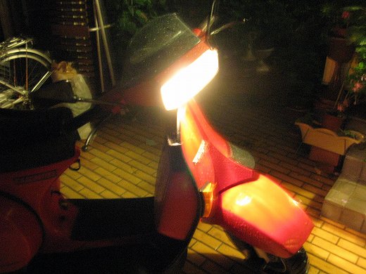 ヘッドライトが点いた赤いベスパの夜間写真（無事始動）
