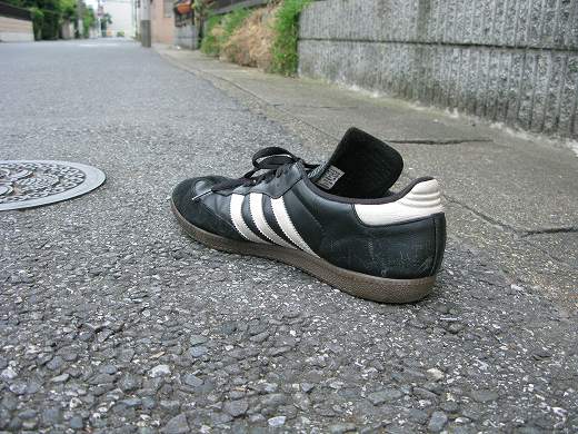 道路上に片方だけ残された黒いスニーカー
