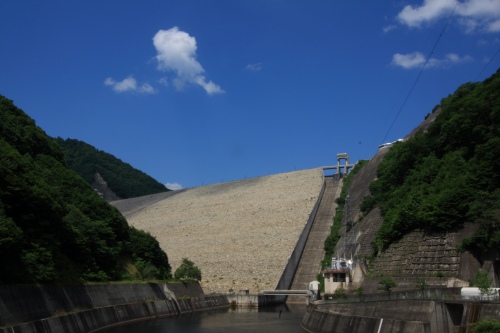 青空の下にそびえる巨大なロックフィル式の奥只見ダム