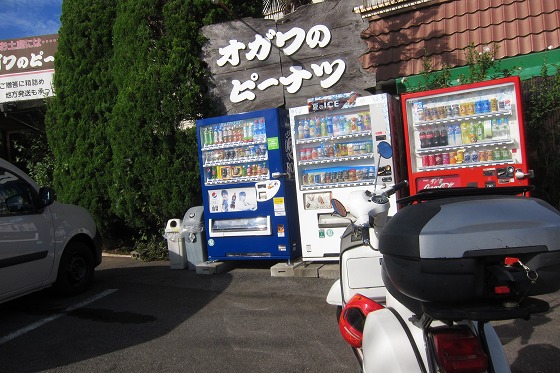 オガワのピーナッツ店前、ベスパと自販機が並ぶ風景
