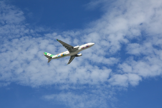 青空を飛ぶ旅客機、快晴の空を背景に力強く飛行