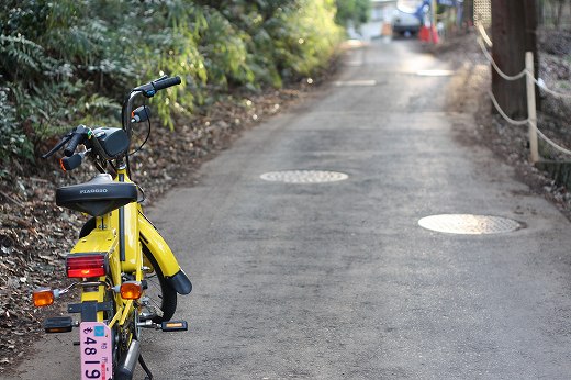 坂道に止まる黄色いCiaoと静かな小道の風景