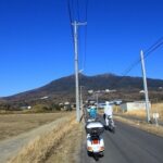 快晴の筑波山をバックにベスパで農道を走る風景