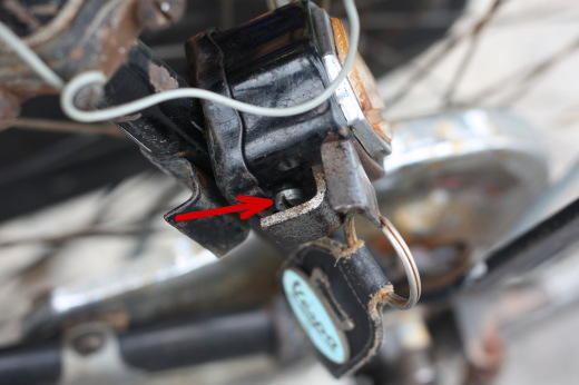 自転車の鍵部分をクローズアップ。赤い矢印がマイナスネジを指している。