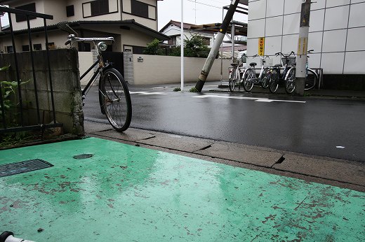 雨に濡れた店先の緑色の床と道路