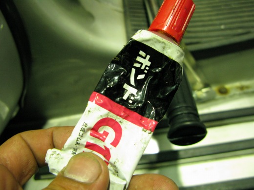 ステップのゴム装着前に接着剤を塗布している様子