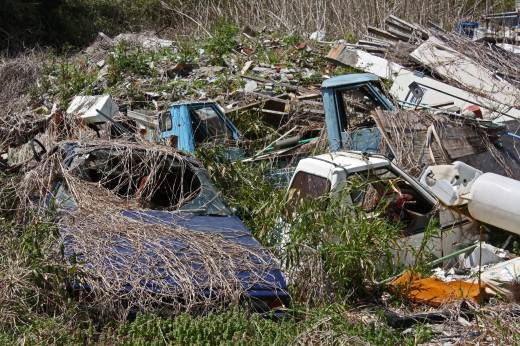 ベスパカーを含むミニカー類が廃棄物と一緒に積まれている風景