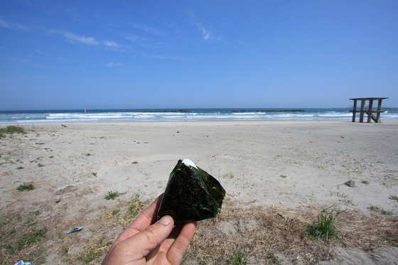 海を背景におにぎりをもぐもぐする瞬間