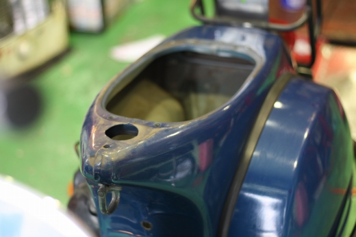 タンクが外されたVespa車体を指差す男性