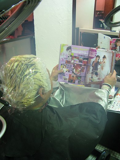 美容室でヘアブリーチ中に雑誌を読む男性