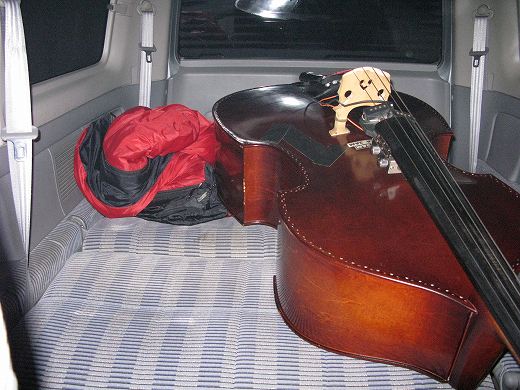ワゴン車の荷室でウッドベースと並んでいる様子
