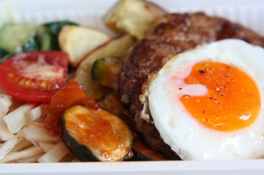 ハンバーグと目玉焼き、野菜が添えられた手作り弁当
