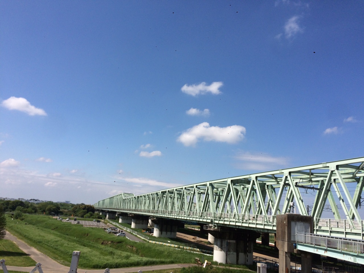 利根川河川敷と鉄橋、青空が広がる爽やかな風景