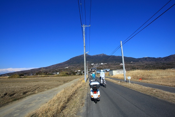 快晴の筑波山をバックにベスパで農道を走る風景