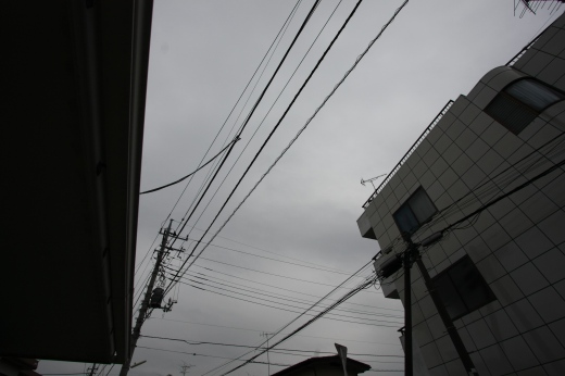 柏の空を覆う冬の厚い雲と電線