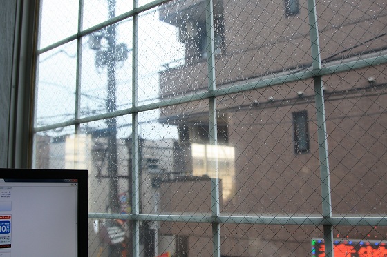 雨で濡れたKB SCOOTERS前の路面と駐車スペース。