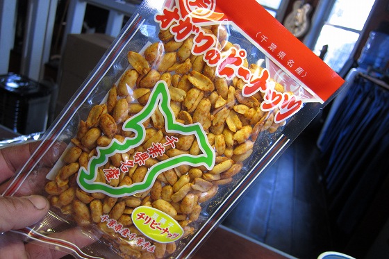 千葉県名産「オガワのピーナッツ」のパッケージを手に持った様子。