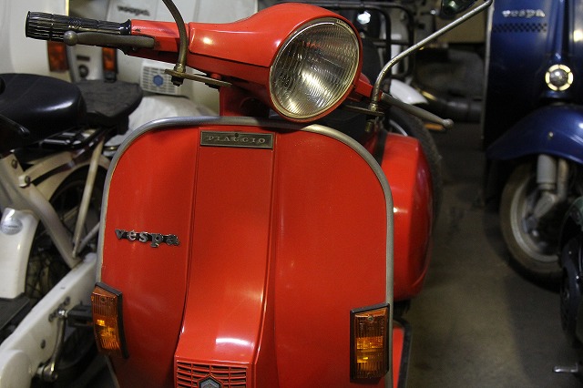 商談中のP125X、店舗前に置かれた赤いベスパ