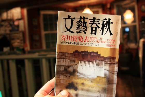文藝春秋3月号を片手に持つ人物の読書風景。